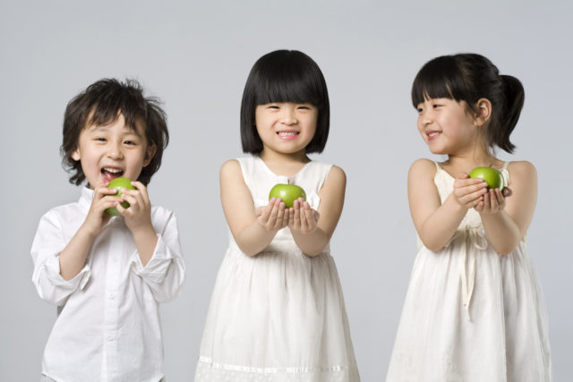 Chinese children each holding an apple